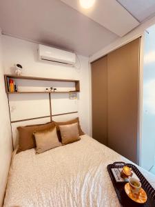 a small bedroom with a bed with a tray on it at Loft encantador A - 8 km de Floripa in São José