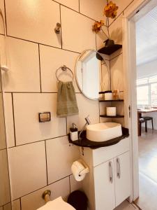 a bathroom with a sink and a mirror at Loft encantador A - 8 km de Floripa in São José