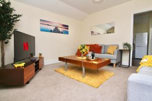 a living room with a tv and a couch at Avenue Place in Leamington Spa