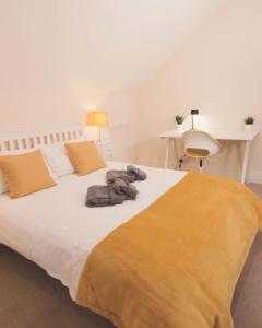 a large bed with a teddy bear laying on it at Avenue Place in Leamington Spa