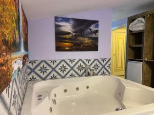La salle de bains est pourvue d'une baignoire blanche et d'une peinture murale. dans l'établissement Castle Light Boutique, à Alanya