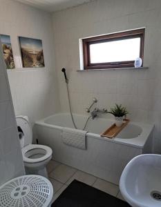 uma casa de banho com uma banheira, um WC e um lavatório. em Vakantiehuis Lauwersmeer em Lauwersoog