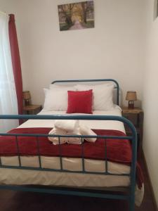 1 cama con marco de metal y almohada roja en Casa da Calçada - Piso 1, en Seia