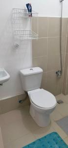 La salle de bains est pourvue de toilettes blanches et d'un lavabo. dans l'établissement Camella Staycation, à Butuan