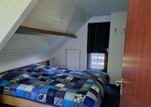 una camera da letto con un letto con un piumone a righe di Vakantiehuis Lauwersmeer a Lauwersoog