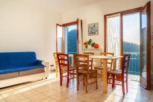un soggiorno con tavolo, sedie e divano di [The Olive Trees]- jacuzzi-garden-wifi-barbecue-parking a Ageno