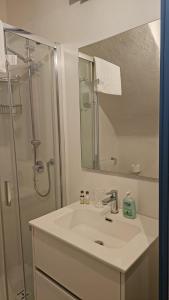 un bagno con lavandino e doccia con specchio di CASA MENOTTI a Sanremo