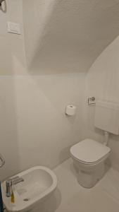 un bagno bianco con un water e un lavandino di CASA MENOTTI a Sanremo