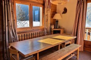 een houten tafel in een kamer met een raam bij Chalet L'isard - Chalets pour 10 Personnes 534 in Peisey-Nancroix