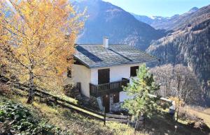 uma casa no lado de uma colina com montanhas em Chalet L'isard - Chalets pour 10 Personnes 534 em Peisey-Nancroix