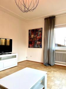 a living room with a flat screen tv and a table at Alex in Pfaffenhausen