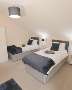 a bedroom with two beds and a pendant light at Avenue Place in Leamington Spa