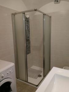 y baño con ducha junto a una lavadora. en Suite alla Terrazza, en Comano Terme