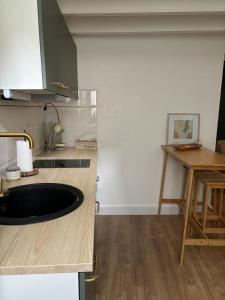 a kitchen with a sink in the middle of a counter at Maisonnette plein centre 2/3p in Libourne