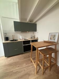 une cuisine avec des placards verts et une table en bois dans l'établissement Maisonnette plein centre 2/3p, à Libourne