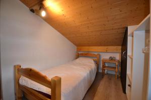 um quarto com uma cama e um tecto de madeira em Résidence La Sapiniere - 4 Pièces pour 5 Personnes 454 em Notre-Dame-de-Bellecombe