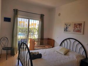 1 dormitorio con 1 cama y puerta corredera de cristal en Sun & Pool Holiday Apartment, en Albufeira