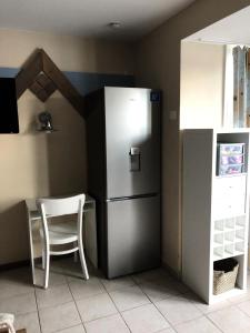 eine Küche mit einem Kühlschrank, einem Tisch und einem Stuhl in der Unterkunft Les Maisons de Belle Dune - maeva Home - Maison 4 Pièces 8 Personnes - Sélection MAE-8641 in Fort-Mahon-Plage