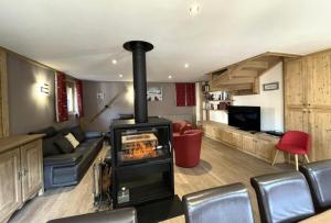 een woonkamer met een houtkachel in een kamer bij Chalet De Manou - Chalet individuel rénové avec sauna dans les 3 Vallées MAE-3694 in Saint-Martin-de-Belleville