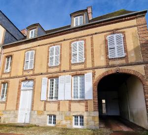 a large brick building with an arch entrance at Studio - Hyper Centre - Proche Gare in Verneuil d’Avre et d’Iton