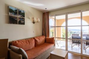 uma sala de estar com um sofá e uma varanda em Résidence le Village de Cap Esterel - maeva Home - Appartement 2 Pièces 5 P 43 em Saint-Raphaël