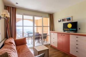 uma sala de estar com um sofá e uma mesa com vista em Résidence le Village de Cap Esterel - maeva Home - Appartement 2 Pièces 5 P 43 em Saint-Raphaël