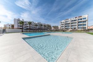 een groot zwembad voor een gebouw bij Casa Cayena - Cosy & Trendy apartment near Villa Martin Golf in Orihuela