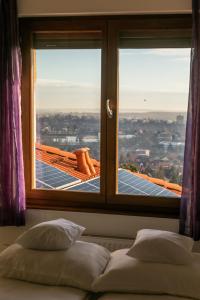 a bedroom with a window with a view of the city at Villa della Vita in Pécs