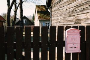 a pink door on a fence next to a house at Kalnciema kvartāla Kuldīgas rezidence in Kuldīga