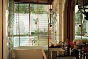 a bathroom with a tub in front of a window at Menara - 3 BR Private Pool Villa - Moroccan Inspired - Bangtao Beach in Phuket