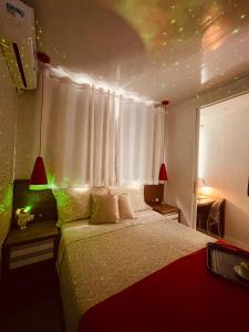 a bedroom with a bed and a window with lights at Loft encantador C - 8 km de Floripa in São José