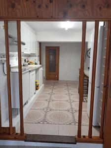 a kitchen with white cabinets and a tile floor at Apartamento Trafalgar in Xeraco