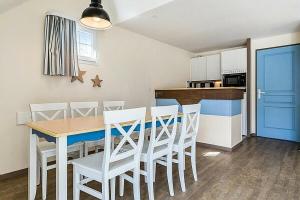 cocina y comedor con mesa y sillas en Résidence Cap Azur - maeva Home - Appartement 3 Pièces 7 Personnes - Confor 52 en Fouesnant