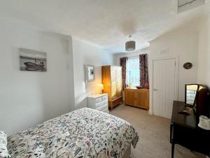 a bedroom with a bed and a dresser and a desk at Ameliafield Cottage, Prestwick in Prestwick