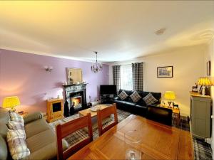 a living room with a couch and a fireplace at Ameliafield Cottage, Prestwick in Prestwick