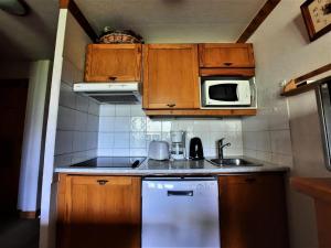una pequeña cocina con fregadero y microondas en Résidence Argentiere - 2 Pièces pour 6 Personnes 864, en Les Menuires