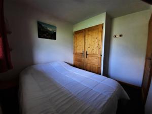 1 dormitorio con cama y puerta en Résidence Argentiere - 2 Pièces pour 6 Personnes 864, en Les Menuires