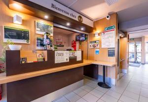 a fast food restaurant with a counter and signage at B&B HOTEL Saint-Etienne La Terrasse in Villars