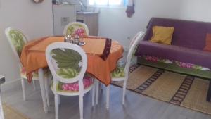 a table and chairs with a table and a couch at Dar Fati Roses in Aït Imouni