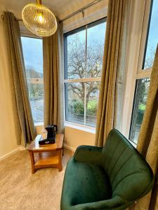a living room with a green chair and a window at Gwydyr Hotel in Betws-y-coed