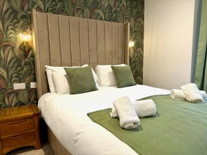 ein Schlafzimmer mit 2 Betten und Handtüchern darauf in der Unterkunft Gwydyr Hotel in Betws-y-coed