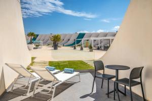 卡塔赫納的住宿－Occidental Mar Menor，球场屋顶上的一组桌椅