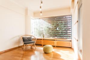 una stanza con una sedia e una finestra con un lavandino di Elegant Maisonette 4BD Glyfada ad Atene