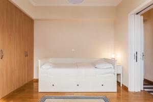 una camera bianca con un letto bianco di Elegant Maisonette 4BD Glyfada ad Atene