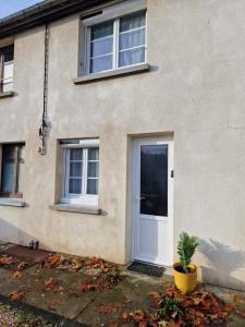 a house with a white door and a plant at Maisonnette en Duplex - Cosy- Centre Ville in Verneuil d’Avre et d’Iton