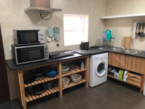 a kitchen with a microwave and a washing machine at Wavecrest in Horta