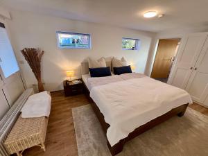 um quarto com uma cama grande com lençóis brancos e almofadas azuis em Appartement „Zum Weißen Hahn“ em Bad Zwischenahn