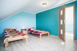 Habitación con 2 camas en una habitación con paredes azules. en Agroturystyka Golubie en Ełk