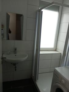 a bathroom with a sink and a window at Anna Zimmer im UG Neu und Modern in Heilbronn