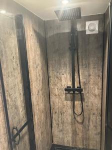 una doccia con tubo fissato a un muro di Schitterend 4 persoons Tinyhouse met HOTTUB aan de bossen in Putten 4-16 a Putten